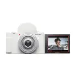 Sony ZV-1F vlog camera in white, front view with the vari-angle screen rotated forward